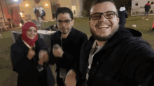 a group of people are posing for a picture and one of them has glasses