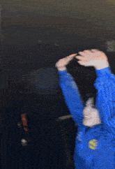 a blurry picture of a person wearing a blue jacket with a yellow e on it