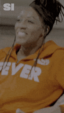 a woman wearing an orange hoodie with the word fever on it