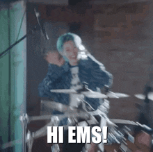 a woman with blue hair is playing drums and the words hi ems are visible in the background .