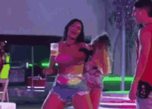 a woman in a pink bikini is dancing in front of a man .