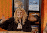 a woman stands in front of a shelf with jamaica and the thing posters