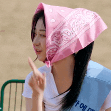 a woman wearing a pink bandana on her head and a blue sash that says ' e ' on it
