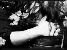 a black and white photo of a person 's arm with diamonds flying around them