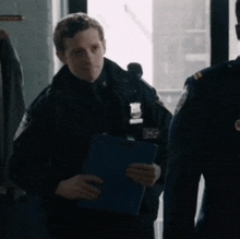 a police officer is holding a clipboard and wearing a badge that says ' nypd '