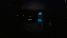 a dark room with a blue light shining through the window
