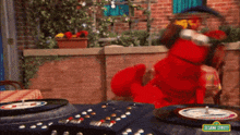 elmo from sesame street is playing a game of roulette on a record player .