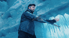 a man in a leather jacket holds a sword in front of ice