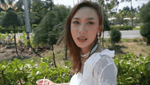 a woman in a white lace top is holding a red cup with a straw