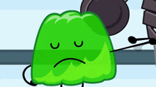 a green cartoon character with a sad face and arms