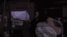 a man in a hockey mask is holding a hockey stick in his hand .