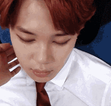 a man with red hair and a white shirt and tie