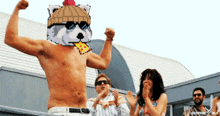 a shirtless man with a pixelated raccoon on his head holds a piece of pizza