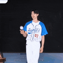 a man wearing a blue and white jersey with the number 07 on it is holding a baseball ..