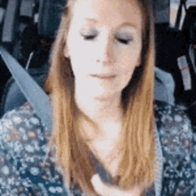 a woman wearing a seat belt is sitting in a car .