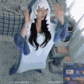a woman in a shark costume is sitting on the floor with her hands in the air
