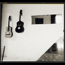 two guitars are hanging on a wall and the date is 23 05 24