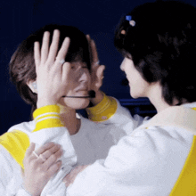 a man with a microphone covering his face while another man looks on