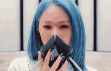 a girl with blue hair is wearing a gas mask .