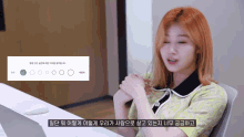 a woman with red hair is sitting at a desk with a laptop and a sign behind her that says ' circle '