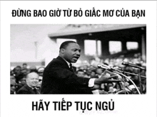 a black and white photo of martin luther king giving a speech in front of a crowd
