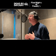 a man wearing headphones is singing into a microphone with dead by daylight at the bottom