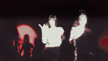 a woman with long nails and red lips is dancing in front of a red light