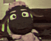 a cartoon sheep is sitting on a couch and looking at the camera .