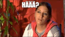 a woman is sitting in front of a plant and making a funny face with the words `` haaa ? ''