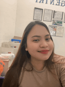 a woman taking a selfie in front of a wall that has a sign that says ' tocoo '
