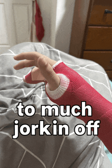 a person with a red cast on their hand is laying on a bed