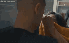 a man is kissing a woman on the cheek while laying on a bed .