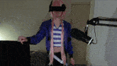 a person wearing a purple jacket and a pink wig is standing in front of a microphone