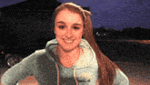 a girl wearing a blue hoodie that says lorong smiles for the camera