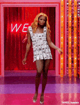 a woman is dancing in front of a sign that says we on it
