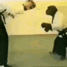 a couple of people are standing next to each other in a room with their arms outstretched .