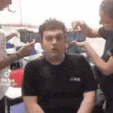 a group of people are taking a picture of a man 's face with their cell phones .