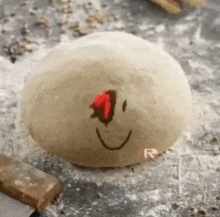 a ball of dough with a smile drawn on it .