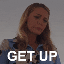 a woman in a blue shirt with the word get up written on it