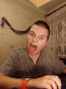 a boy sticking his tongue out and wearing a watch