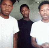 three young men in white shirts are standing next to each other in a room .