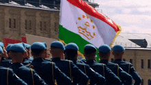 a group of soldiers marching in front of a flag that says tajikistan