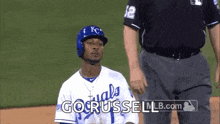 a baseball player wearing a kc uniform is kneeling down on the field