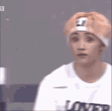 a young man wearing a headband and a t-shirt with the word lover on it