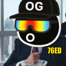 a man in a suit and tie is wearing sunglasses and a hat with og on it