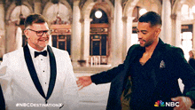 two men in tuxedos are standing next to each other in front of a building with nbc written on the bottom right