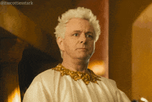 a man with white hair is wearing a white robe with gold collar