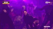 a woman is dancing in front of a mnet sign