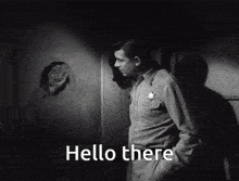 a man in a sheriff 's uniform is standing in front of a hole in a wall and says hello there