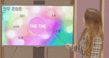 a woman pointing at a screen that says " the the "
